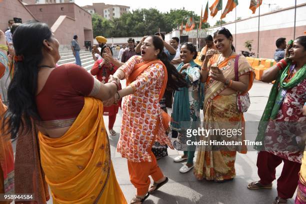 Workers celebrate at party headquarter after BJP emerged as the single largest party in Karnataka Assembly elections on May 15, 2018 in New Delhi,...