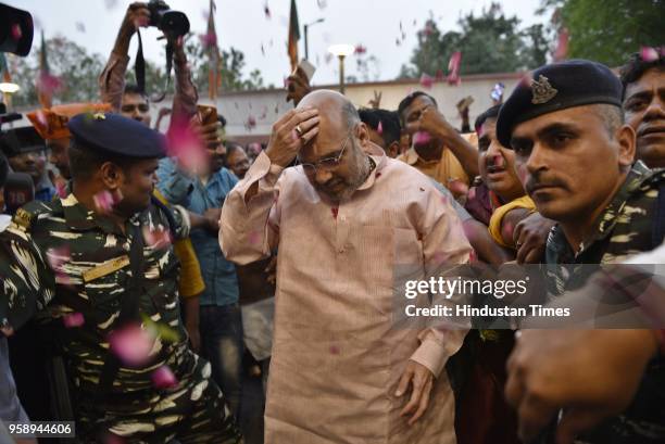 President Amit Shah is showered with flower petals as he arrives at the BJP Headquarters after BJP emerged as the single largest party in Karnataka...