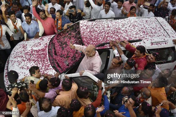 President Amit Shah is showered with flower petals as he arrives at the BJP Headquarters after BJP emerged as the single largest party in Karnataka...