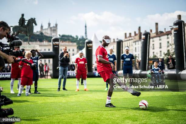 Eric Abidal kicks a ball with a mask to feel like a blind player during the EqualGame Match at the Fan Zone ahead of the UEFA Europa League Final...