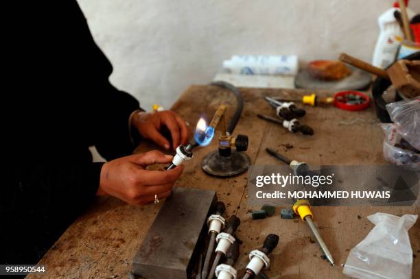 Safaa al-Faqih, one of the few female Yemeni craftsmen working in the precious stones industry in Yemen, crafts a stone in the old city of the...