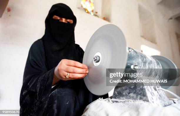 Safaa al-Faqih, one of the few female Yemeni craftsmen working in the precious stones industry in Yemen, crafts a stone in the old city of the...