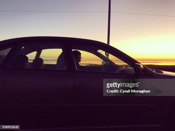 family watching sunset from car - küstenschutzgebiet assateague island stock-fotos und bilder