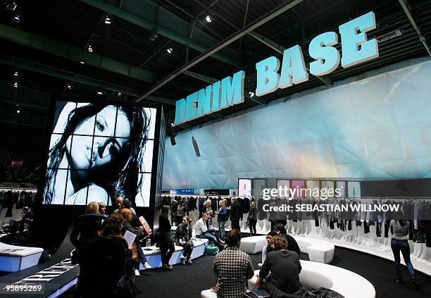 Visitors check through a fashion stand at former Berlin-Tempelhof airport during the "Bread & Butter" trade fair for Street and Urban Wear on January...