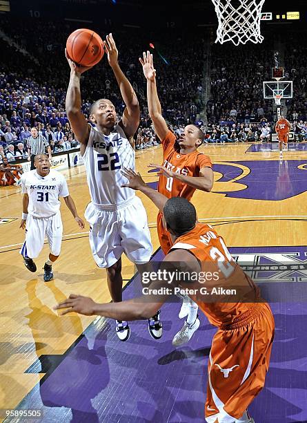 Guard Rodney McGruder of the Kansas State Wildcats scores against pressure from defenders Avery Bradley and Justin Mason of the Texas Longhorns in...