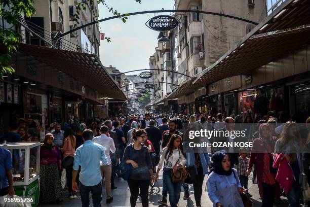 Pedestrians walk on a shopping street in Gaziantep, in the south-west province of Turkey on May 1, 2018. - In the Turkish city of Gaziantep, home to...