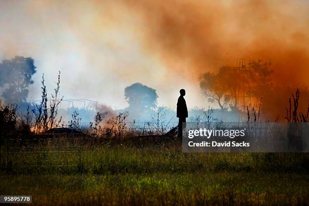 man on smoky field - controlled fire stockfoto's en -beelden