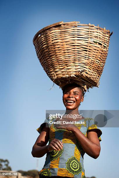 woman carrying basket - carrying on head stockfoto's en -beelden