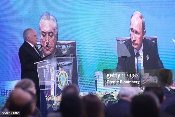 An image of Michel Temer, Brazil's president, and Vladimir Putin, Russia's president, is displayed on a screen as Temer speaks during a ceremony...