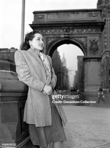 Caption from Down Beat: Ann Hathaway poses with a background of the Arch of Triumph in Washington Square, through which may be seen the Fifth Avenue...
