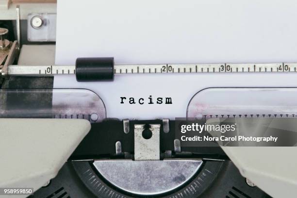 racism typed on vintage typewriter - racism stock pictures, royalty-free photos & images