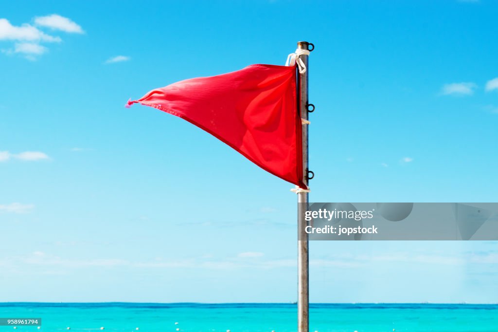 Red warning flag on the beach