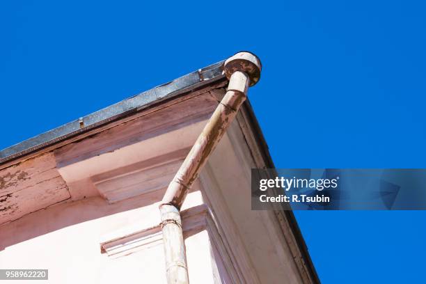 rain gutters on old home. there is a blue sky in the background. - rock overhang stock pictures, royalty-free photos & images