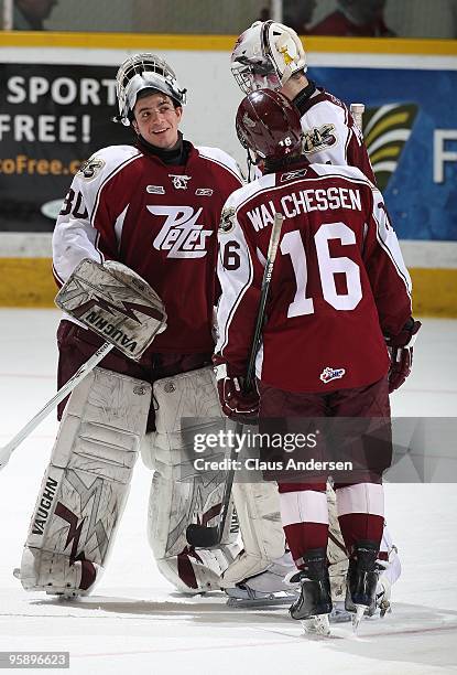 Andrew D'Agostini of the Peterborough Petes congratulates teammate Jason Missiaen on his victory as Jack Walchessen looks on after a game against the...