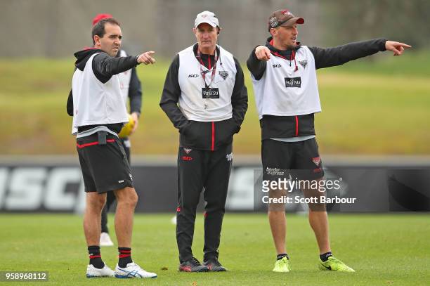 John Worsfold , coach of the Bombers looks on as Rob Harding , Game Intelligence & Opposition Strategy Coach and James Kelly, Performance Coach...