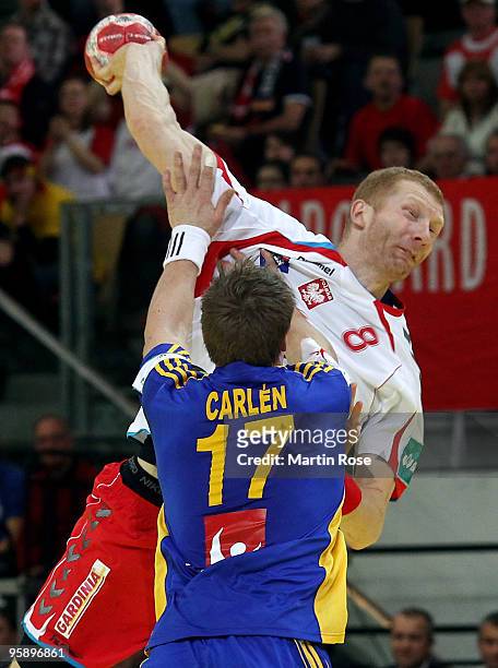 Karol Bielecki of Poland tackles Oscar Carlen of Sweden during the Men's Handball European Championship Group C match between Poland and Sweden at...