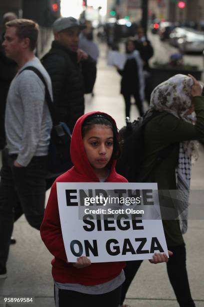 Members of the Palestinian community and their supporters march toward the Israeli consulate to protest President Donald Trump's decision to move the...