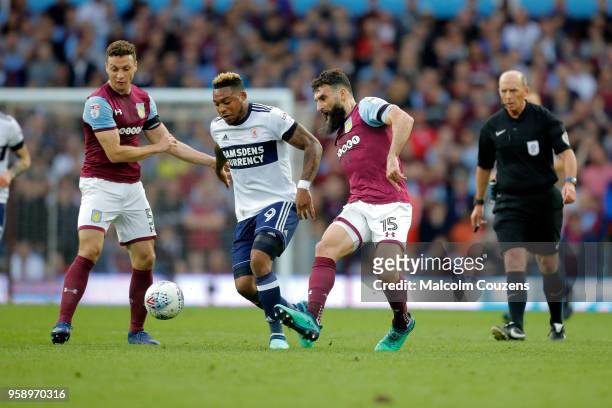 Britt Assombalonga of Middlesbrough is challenged by James Chester and Mile Jedinak of Aston Villa during the Sky Bet Championship Play Off Semi...