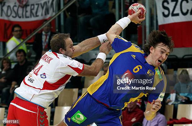 Mariusz Jurasik of Poland tackles Jonas Kaellman of Sweden during the Men's Handball European Championship Group C match between Poland and Sweden at...