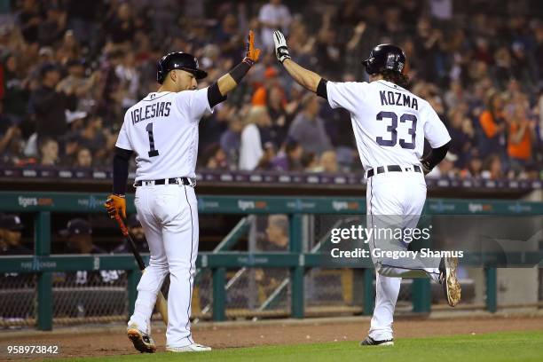 Pete Kozma of the Detroit Tigers celebrates scoring a run in the seventh inning with Jose Iglesias playing the Cleveland Indians at Comerica Park on...