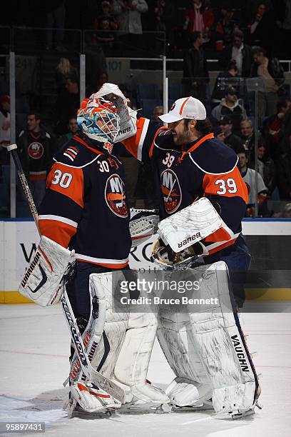 Rick DiPietro of the New York Islanders congratulates Dwayne Roloson following the game against the Detroit Red Wings at the Nassau Coliseum on...