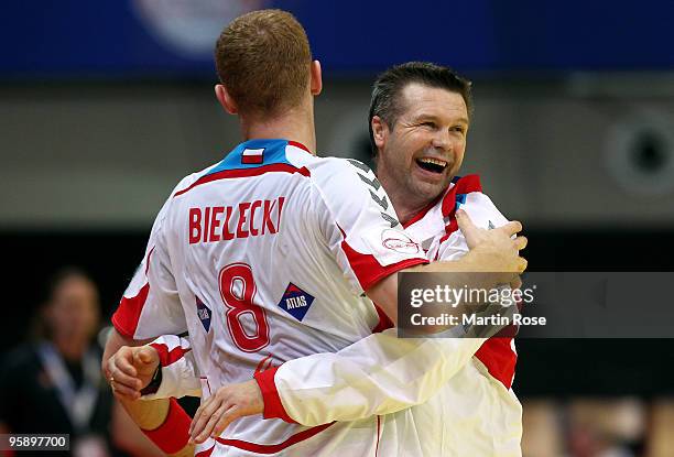 Head coach Bogdan Wenta of Poland celebrate with team mate Karol Bielecki after the Men's Handball European Championship Group C match between Poland...