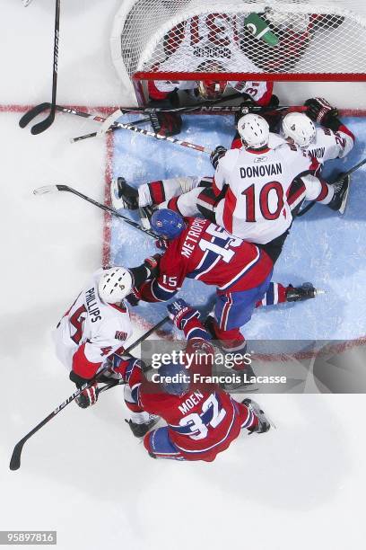 Travis Moen of Montreal Canadiens and teammate Glen Metropolit battles for the puck with Chris Phillips of the Ottawa Senators and teammate Shean...