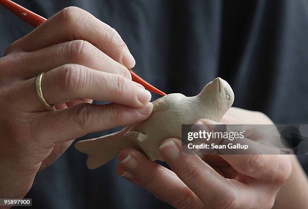 An artisan carves details into a still soft porcelain bird at the manufactury of German luxury porcelain maker Meissen on January 20, 2010 in...