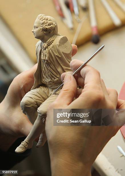 An artisan carves details into a still soft porcelain figurine at the manufactury of German luxury porcelain maker Meissen on January 20, 2010 in...