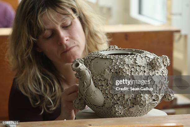 An artisan works on an intricately decorated porcelain teepot at the manufactury of German luxury porcelain maker Meissen on January 20, 2010 in...