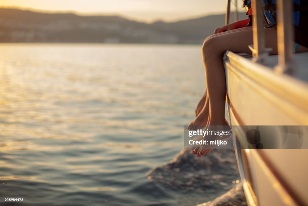 Children sitting on sailboat deck while sailing