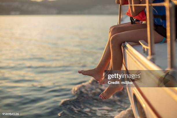 children sitting on sailboat deck while sailing - miljko stock pictures, royalty-free photos & images