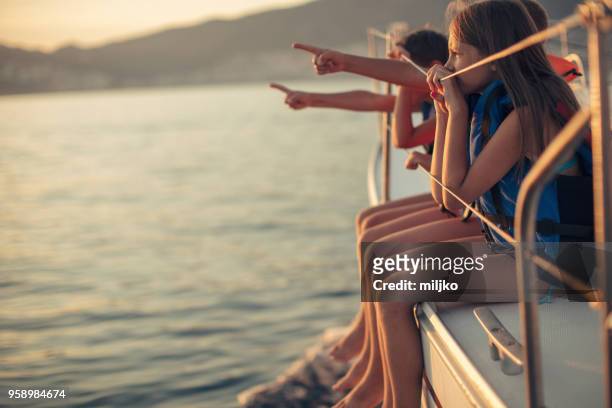 children sitting on sailboat deck while sailing - miljko stock pictures, royalty-free photos & images