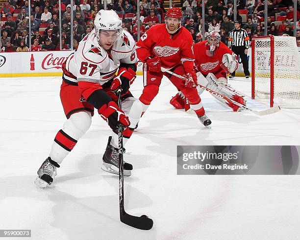 Jerome Samson of the Carolina Hurricanes controls the puck in front of Brad Stuart and goaltender Jimmy Howard of the Detroit Red Wings during a NHL...