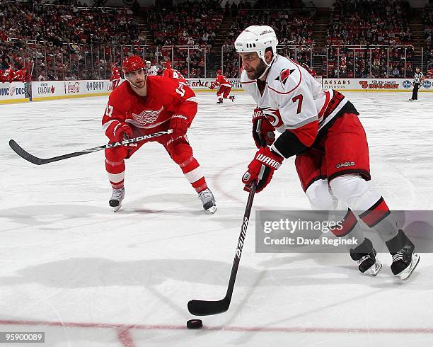 Niclas Wallin of the Carolina Hurricanes skates around the net in front of Patrick Eaves of the Detroit Red Wings during a NHL game at Joe Louis...