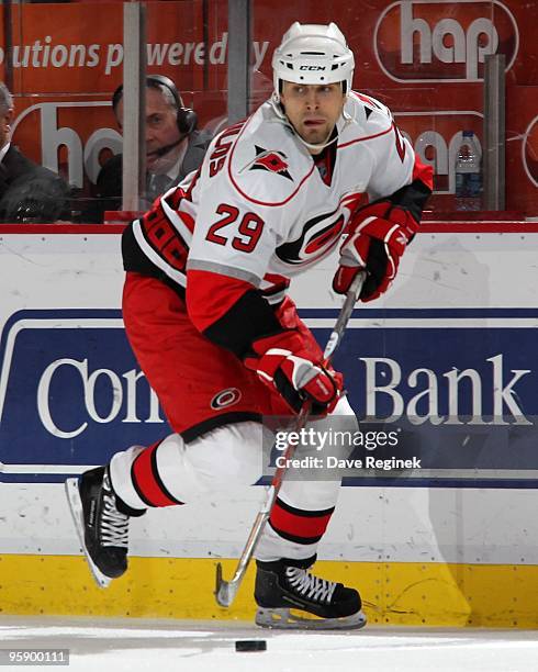 Tom Kostopoulos of the Carolina Hurricanes skates up ice with the puck during a NHL game against the Detroit Red Wings at Joe Louis Arena on January...