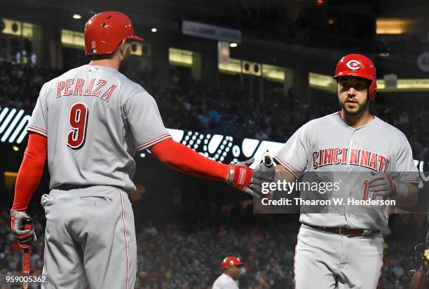 Tony Cruz of the Cincinnati Reds is congratulated by Jose Peraza after Cruz scored against the San Francisco Giants in the top of the fourth inning...