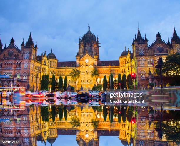 view of train station at night with reflection - mumbai skyline stock-fotos und bilder