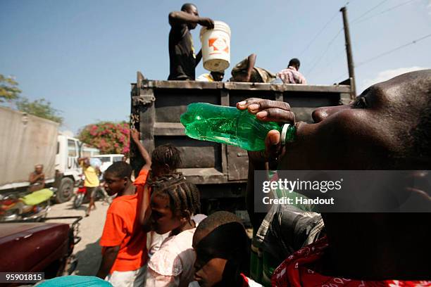 In this handout image provided by the United Nations Stabilization Mission in Haiti , a group of young men pass out water to anyone who has a...