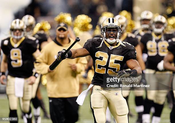 Reggie Bush of the New Orleans Saints carries a bat with him as he leads his teammates onto the field against the Arizona Cardinals during the NFC...
