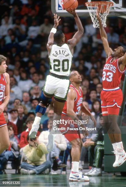 Jeff Grayer of the Milwaukee Bucks shoots over Hersey Hawkins of the Philadelphia 76ers during an NBA basketball game circa 1990 at the Bradley...