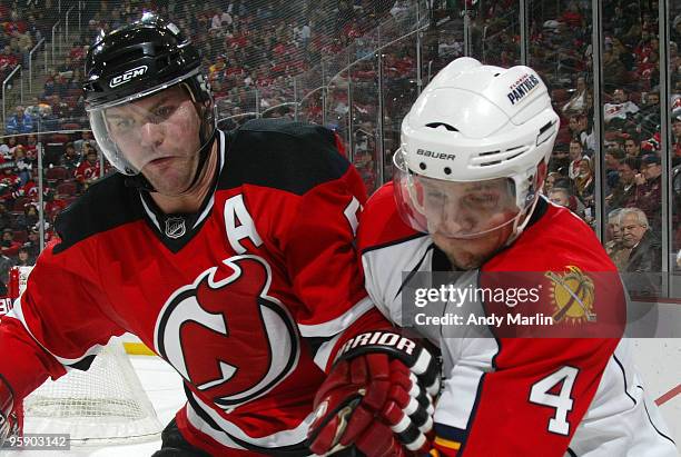 Dennis Seidenberg of the Florida Panthers and Colin White of the New Jersey Devils battle for position during their game at the Prudential Center on...