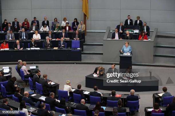 German Chancellor and leader of the German Christian Democrats Angela Merkel is seen on a monitor as she addresses the Bundestag during debates over...