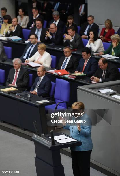 German Chancellor and leader of the German Christian Democrats Angela Merkel is seen on a monitor as she addresses the Bundestag during debates over...