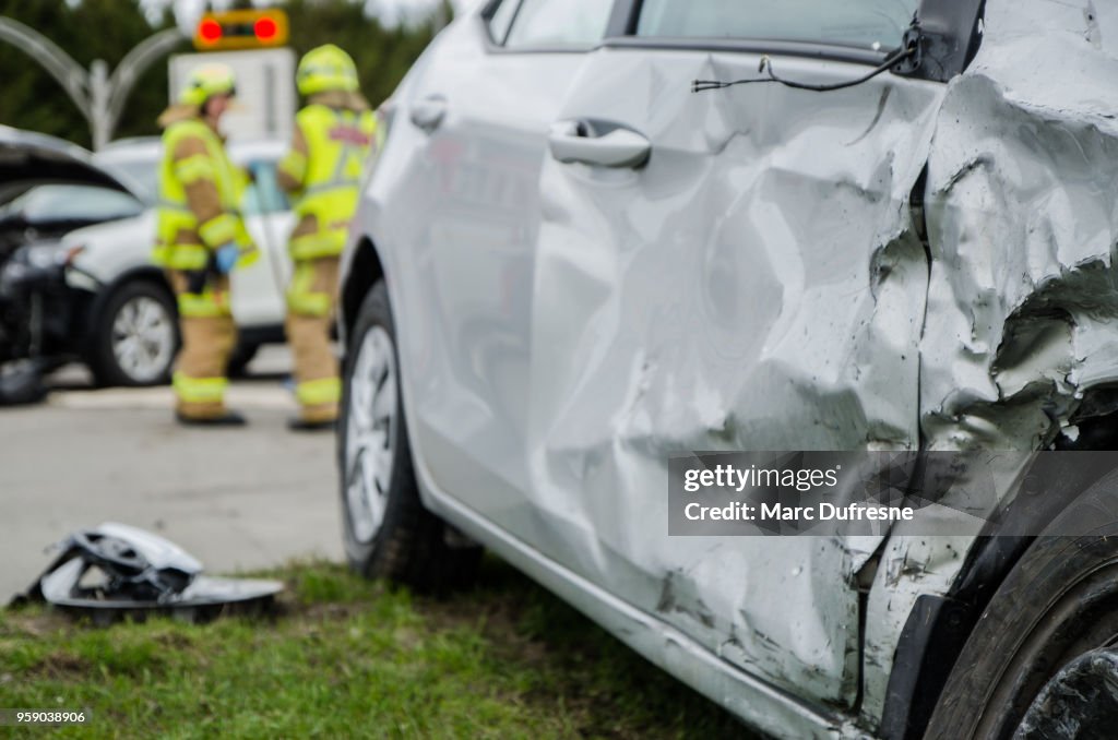 Hautnah auf einem Auto stürzte mit Feuerwehrmann im Hintergrund