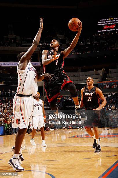 DeSagana Diop of the Charlotte Bobcats blocks against Dorell Wright of the Miami Heat on January 20, 2010 at the Time Warner Cable Arena in...