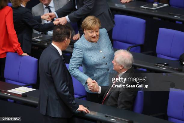 German Chancellor Angela Merkel greets Interior Minister Horst Seehofer as she arrives for debates at the Bundestag over the federal budget on May...