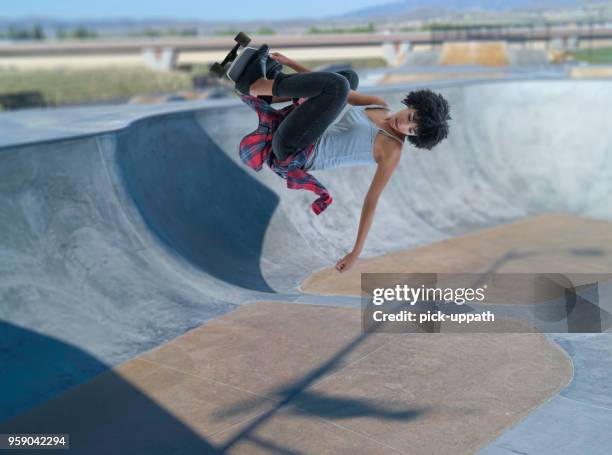 young women jumping on skateboard - women skateboarding stock pictures, royalty-free photos & images