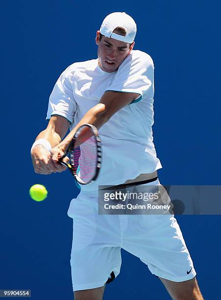 John Isner of the USA plays a backhand in his first round doubles match with Sam Querrey of the USA against Jeff Coetzee of South Africa and Rogier...