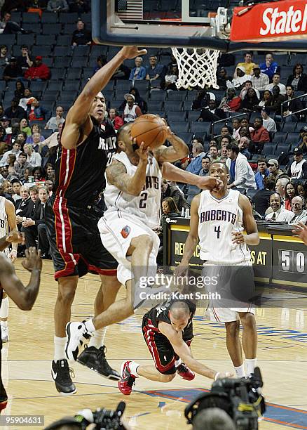 Jamaal Magloire of the Miami Heat blocks against Acie Law of the Charlotte Bobcats on January 20, 2010 at the Time Warner Cable Arena in Charlotte,...